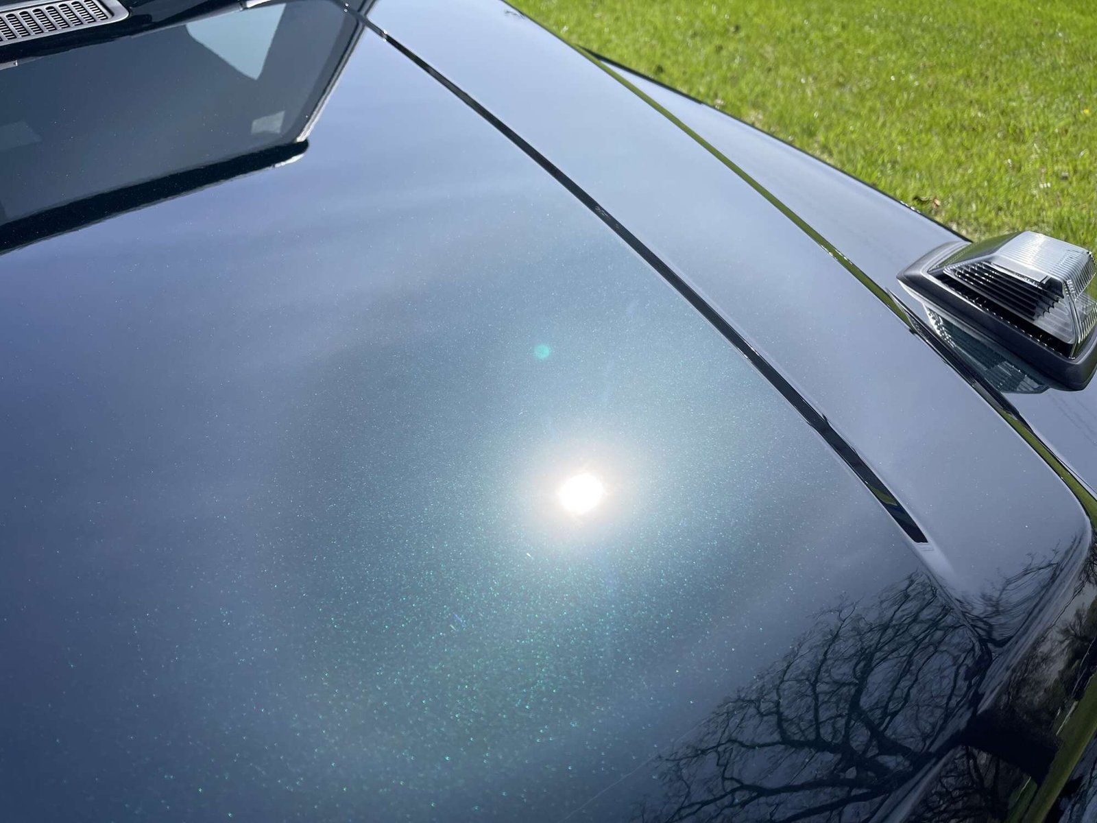 Ceramic-Coating-Deep-Gloss-Detail Close-up of a Mercedes G-Wagon hood after ceramic coating, sun reflecting off deep gloss